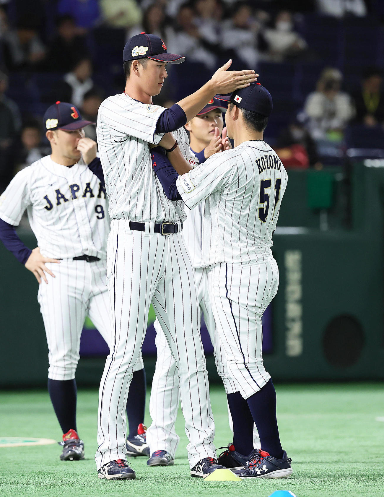 練習中、じゃれ合う秋広（左）と小園（撮影・足立雅史）