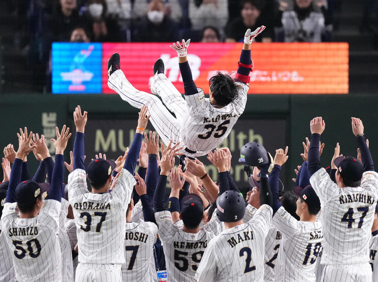 日本対韓国　優勝し、サヨナラの適時打を放った門脇（上）はナインから胴上げされる（撮影・菅敏）