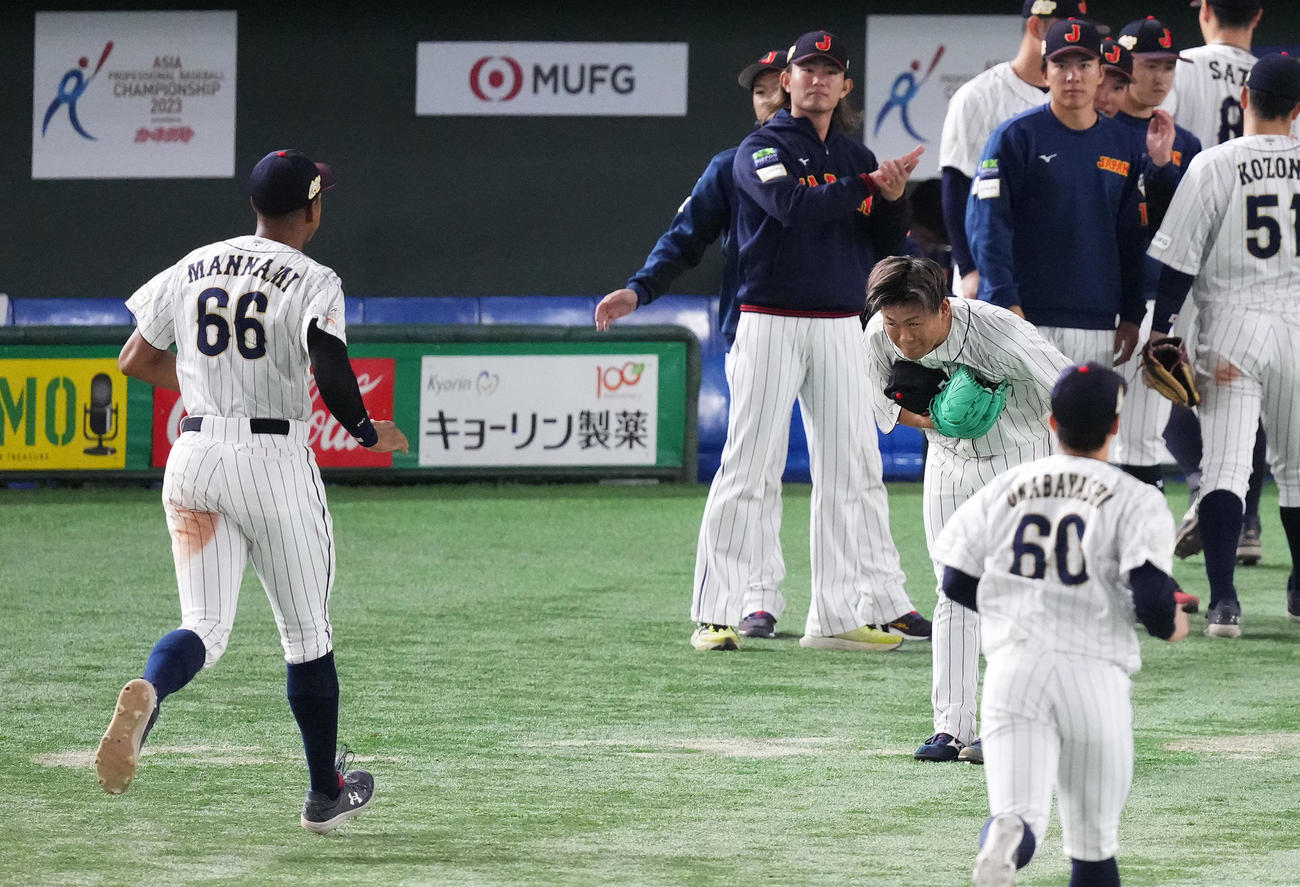 日本対韓国　9回の投球を終え、ベンチに戻る万波（左）にお辞儀をする田口（撮影・菅敏）