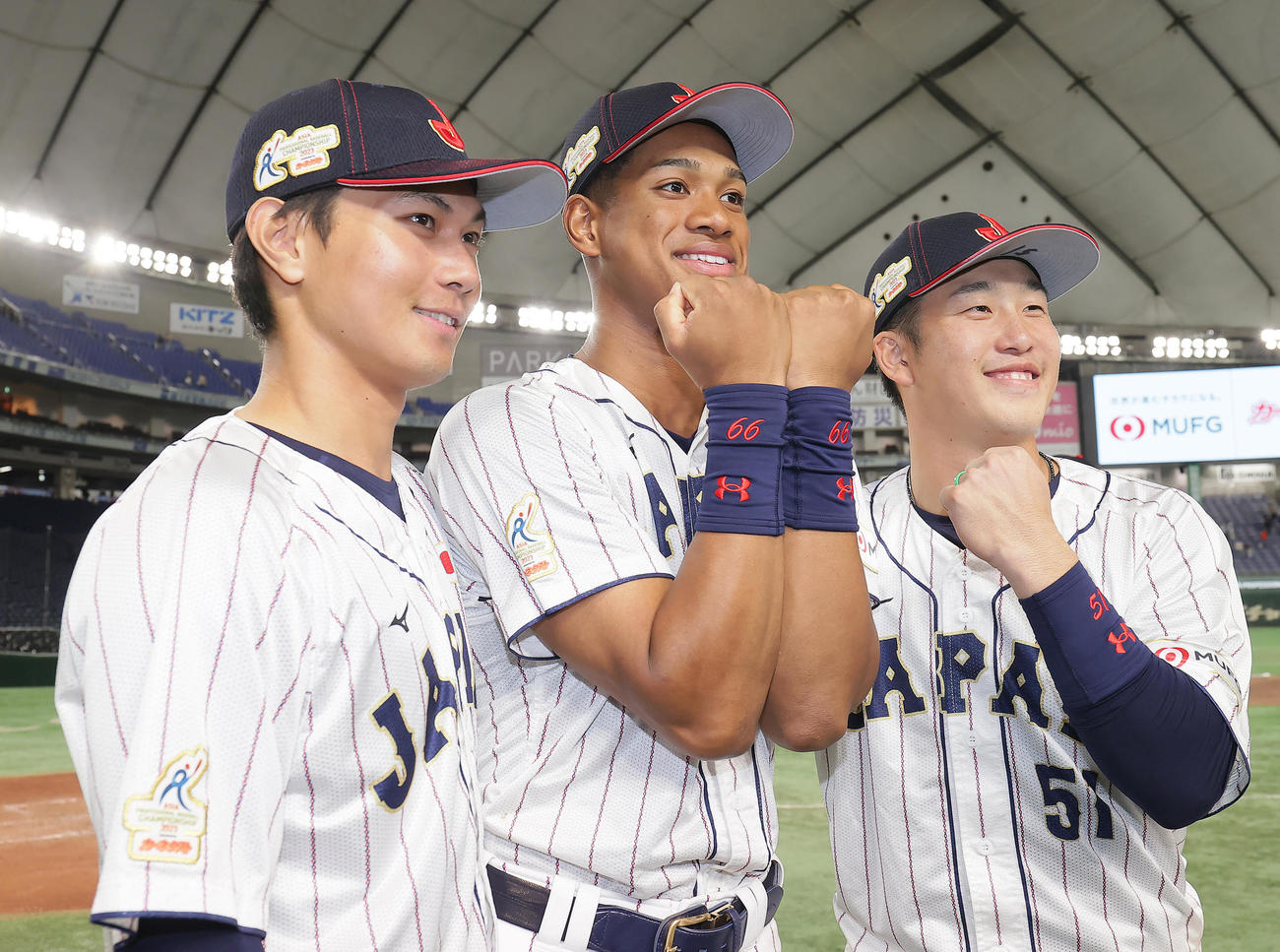 日本対韓国　優勝の記念撮影に臨む、左から藤原、万波、小園（撮影・足立雅史）