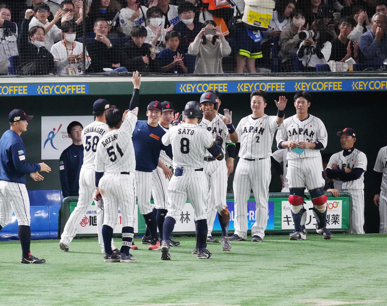 日本対韓国　6回裏日本1死三塁、同点の中犠飛を放った佐藤輝（中央左）とタッチをする生還した万波（撮影・菅敏）