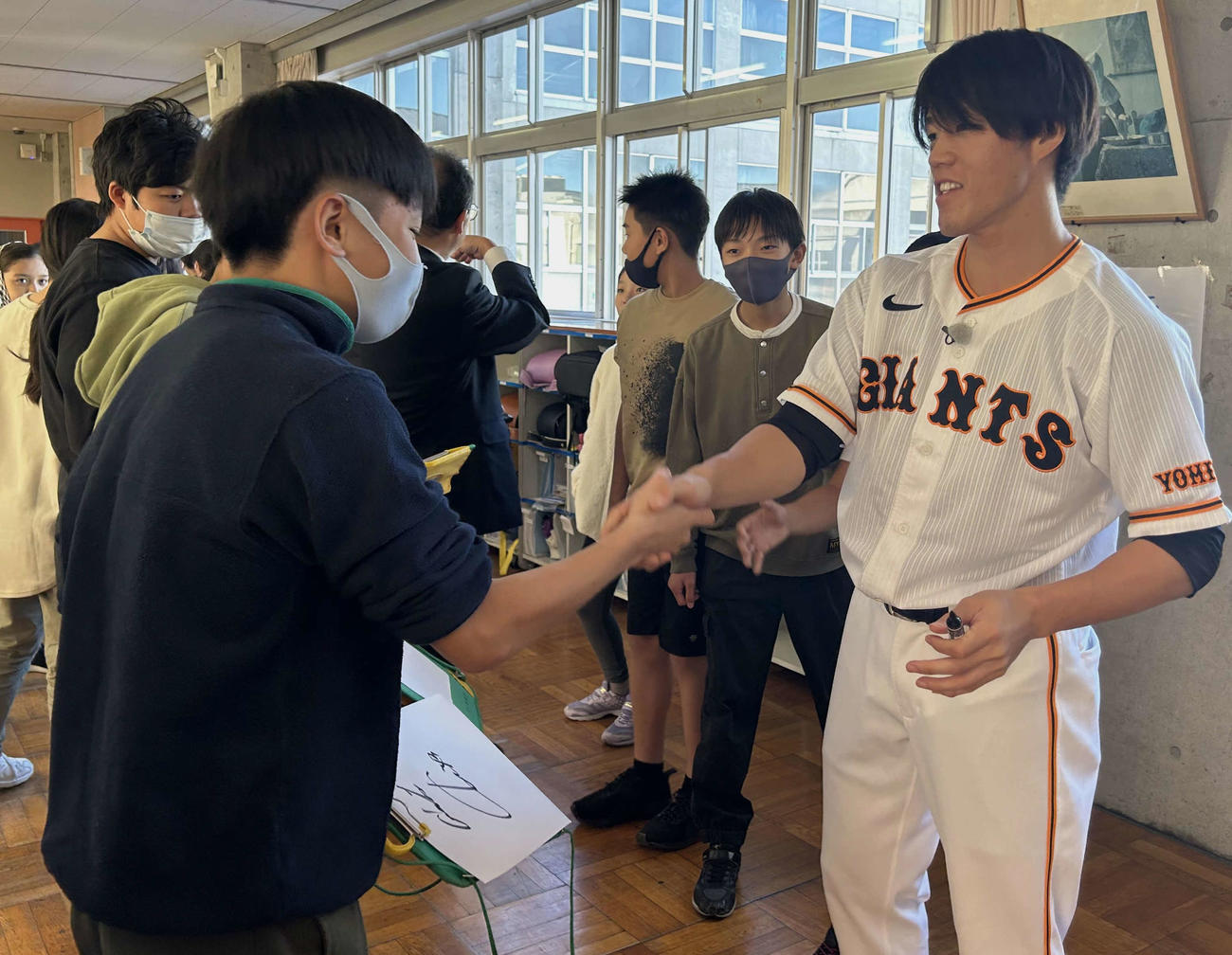 児童と握手を交わす巨人重信（右）（撮影・黒須亮）