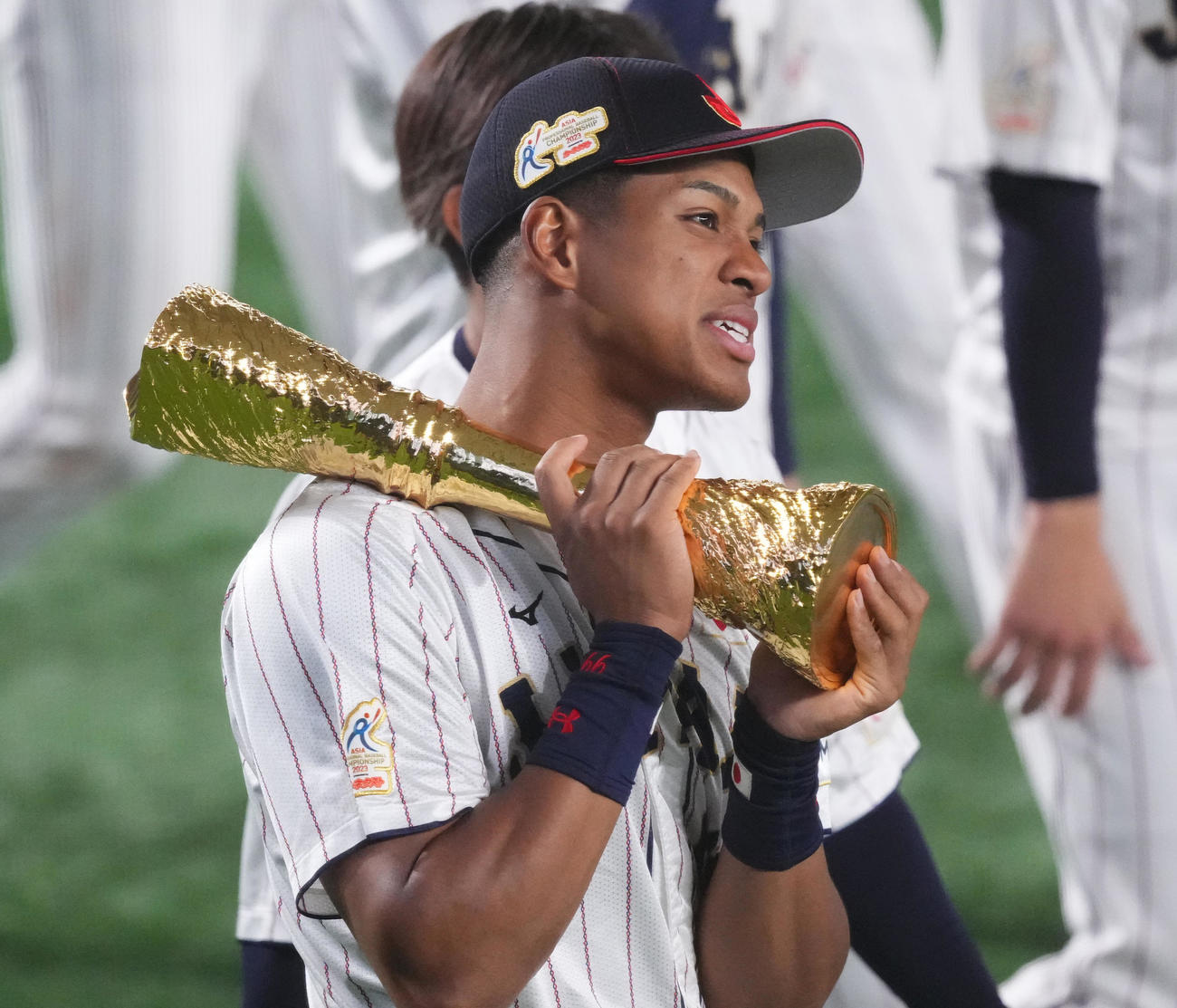 19日、優勝トロフィーを担ぎ場内1周する万波