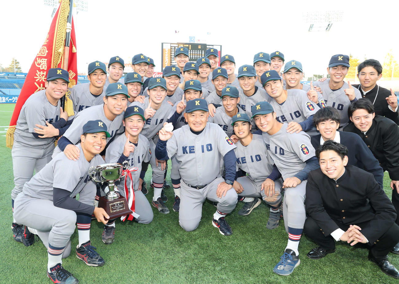 慶大対青学大　優勝しウイニングボールを手に選手と喜ぶ慶大・堀井監督（中央）（撮影・野上伸悟）