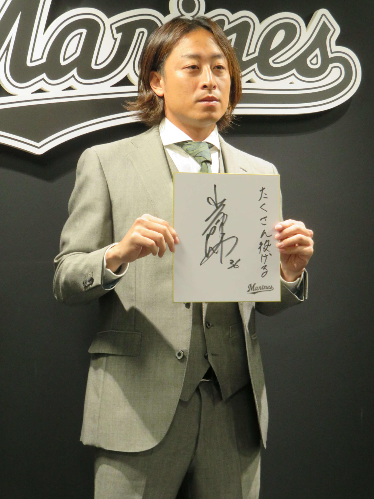 契約更改を終え、色紙に「たくさん投げる」としたためたロッテ坂本