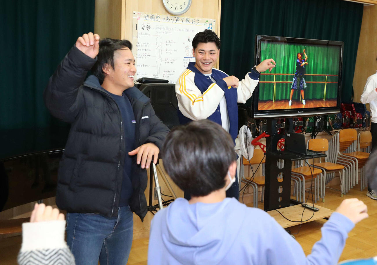 北広島・西の里小学校の子どもたちと「きつねダンス」を踊る日本ハム奈良間（左）と清宮（撮影・黒川智章）