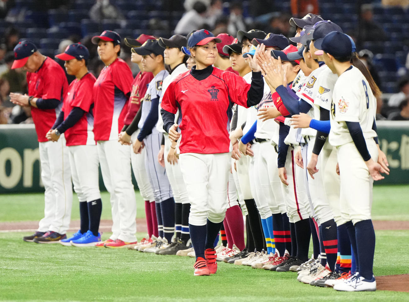 イチロー選抜対高校野球女子選抜　試合前、高校野球女子選抜の選手たちとタッチを交わす中島監督（撮影・江口和貴）