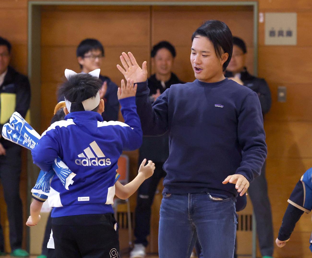 北広島・西の里小学校を訪れ子どもたちハイタッチする日本ハム奈良間（撮影・黒川智章）
