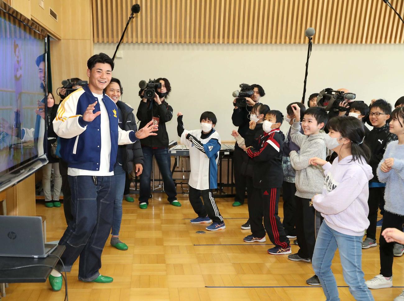 北広島・西の里小学校を訪れ、子どもたちの「きつねダンス」で出迎えられる日本ハム清宮（左）と奈良間（撮影・黒川智章）