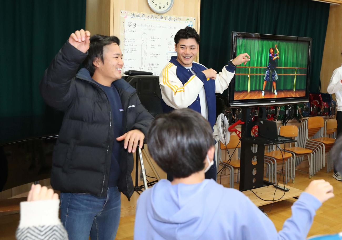 北広島・西の里小学校の子どもたちと「きつねダンス」を踊る日本ハム奈良間（左）と清宮（撮影・黒川智章）