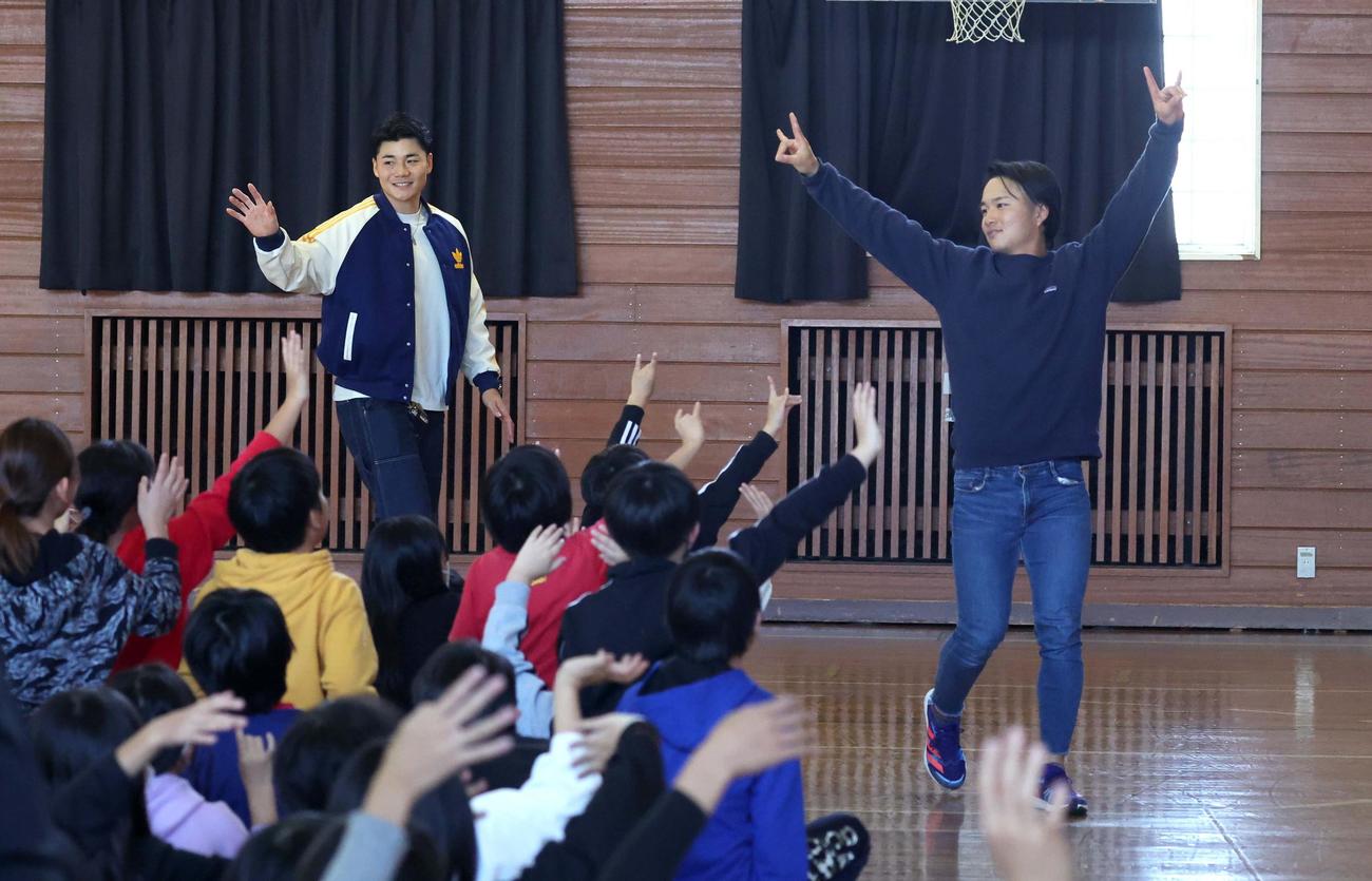長沼小学校の子どもたちに手を振られ引き揚げる日本ハム清宮（左）と奈良間（撮影・黒川智章）