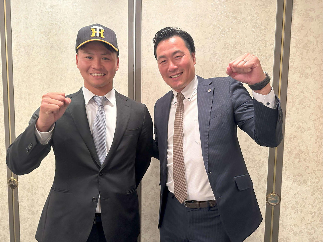 阪神と仮契約を交わし笑顔を見せる育成1巡目指名の日本海リーグ富山・松原（左）と筒井スカウト（球団提供）