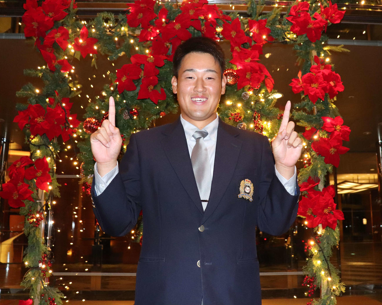 西武ドラ2大商大・上田がはじけた笑みを見せ、背番号11ポーズをつくる（撮影・中島麗）