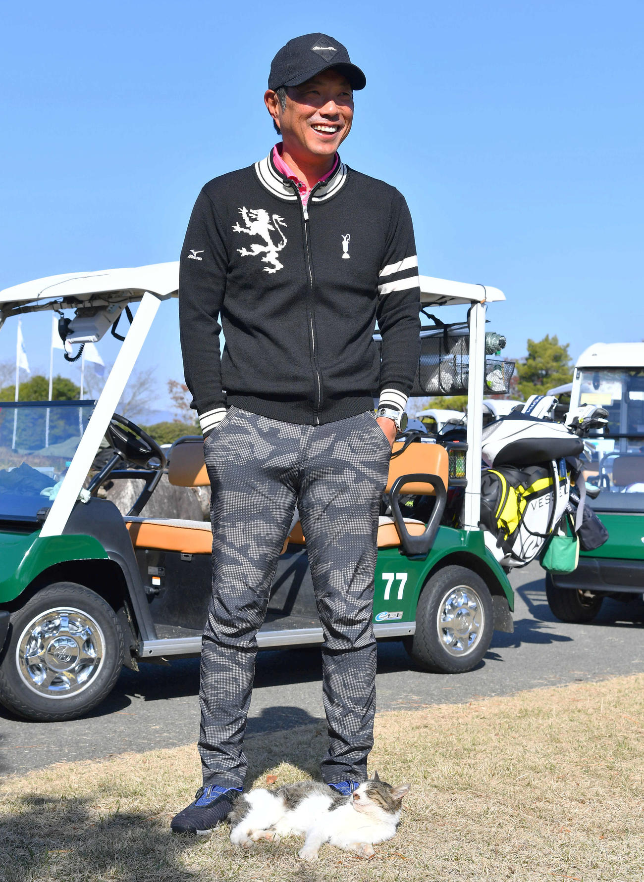 ゴルフ場にすみつく猫が足元から離れず、笑う小久保監督（撮影・岩下翔太）