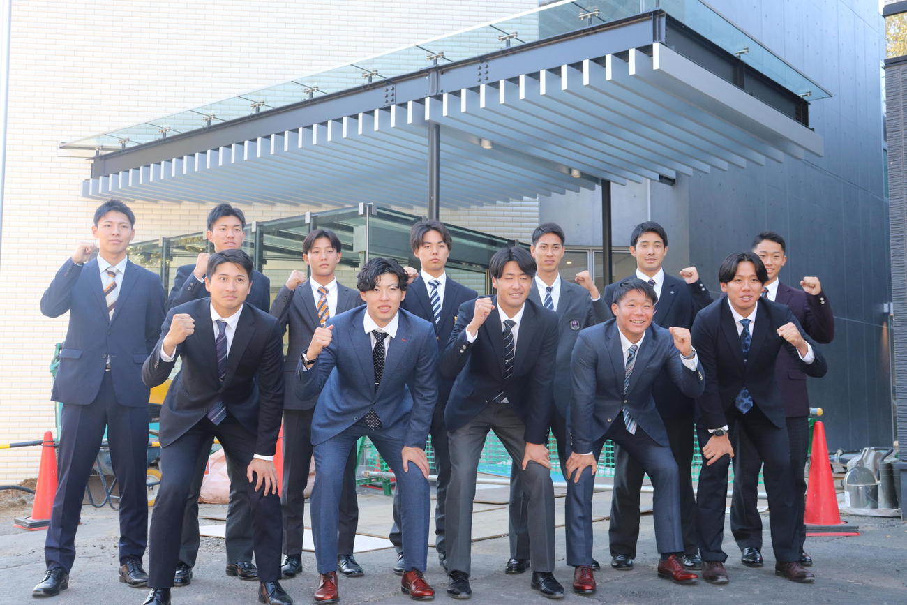 新しいジャイアンツ寮の前で記念撮影する巨人の新人選手たち。前列左から泉口、森田、西舘、佐々木、又木、後列左から平山、園田、宇都宮、三浦、村山、田上、千葉（撮影・小早川宗一郎）
