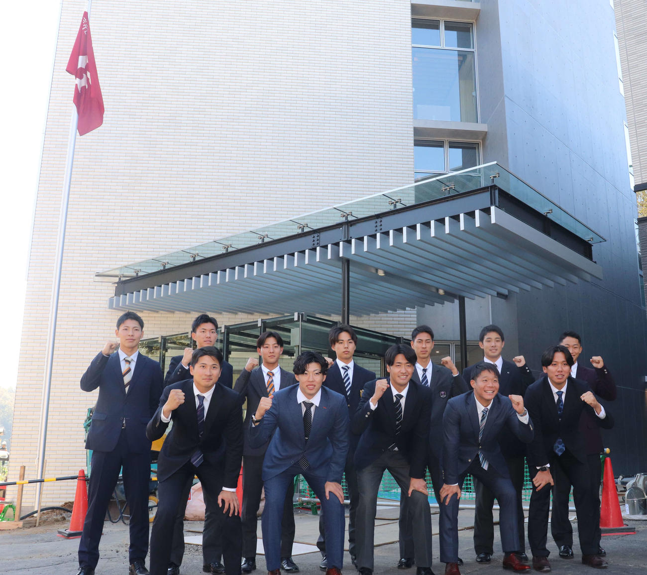 新しいジャイアンツ寮の前で記念撮影する巨人の新人選手たち。前列左から泉口、森田、西舘、佐々木、又木、後列左から平山、園田、宇都宮、三浦、村山、田上、千葉（撮影・小早川宗一郎）