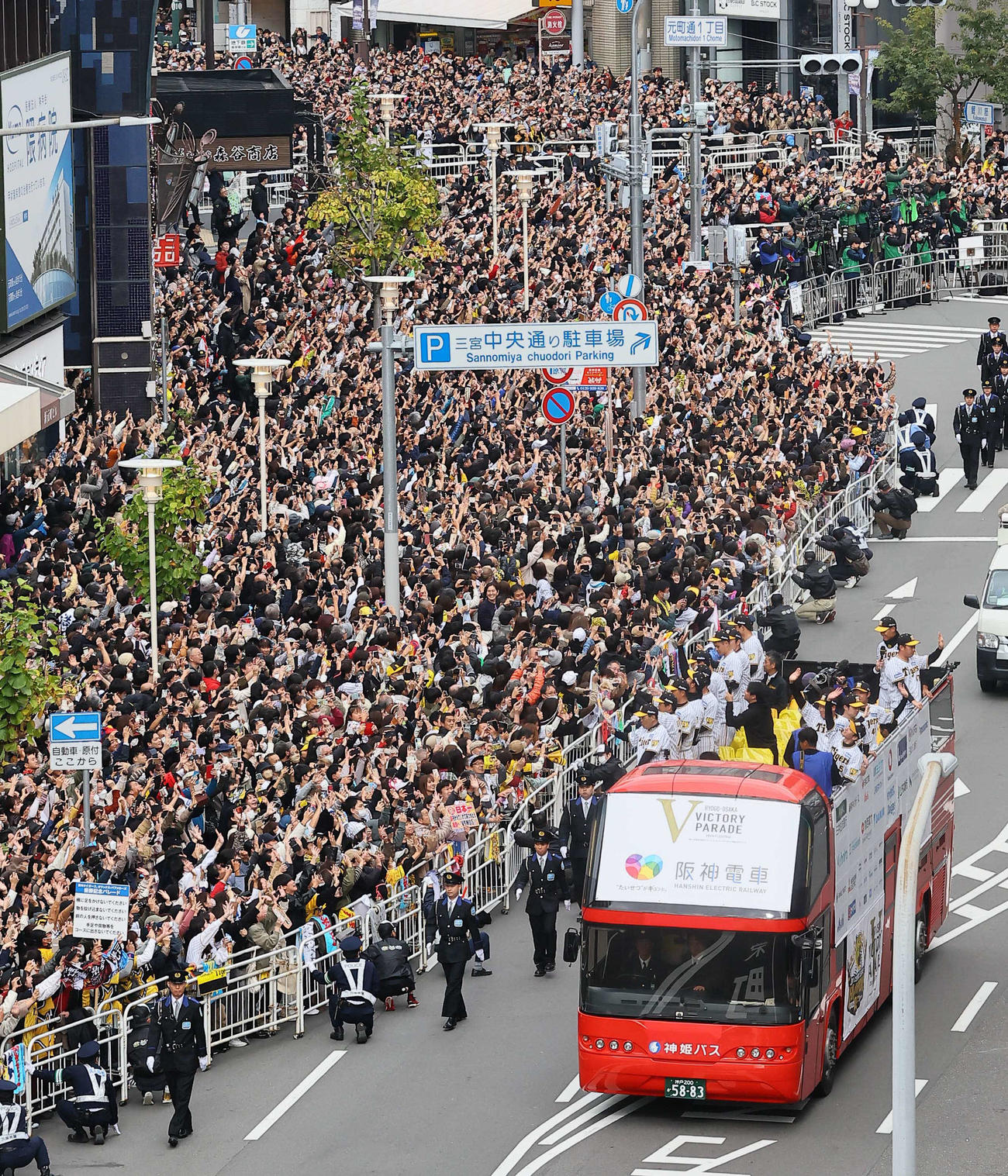 大勢のファンの歓声を受けながら神戸でVパレードをする岡田監督（左列手前）と阪神ナイン（撮影・上田博志）