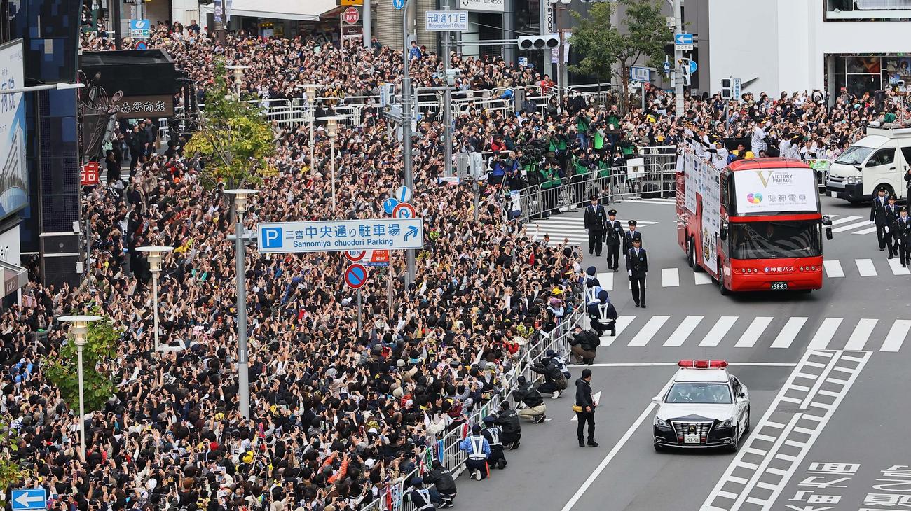 大勢のファンの歓声を受けながら神戸でVパレードをする岡田監督（左列手前）と阪神ナイン（撮影・上田博志）