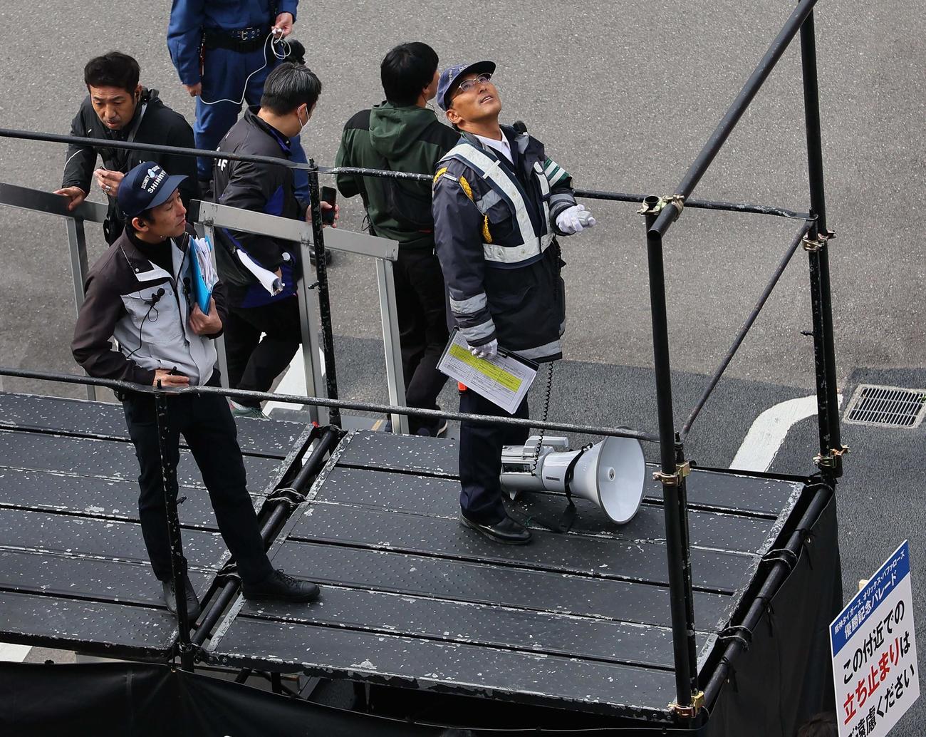 報道ヘリコプターを見上げるDJポリス（撮影・上田博志）