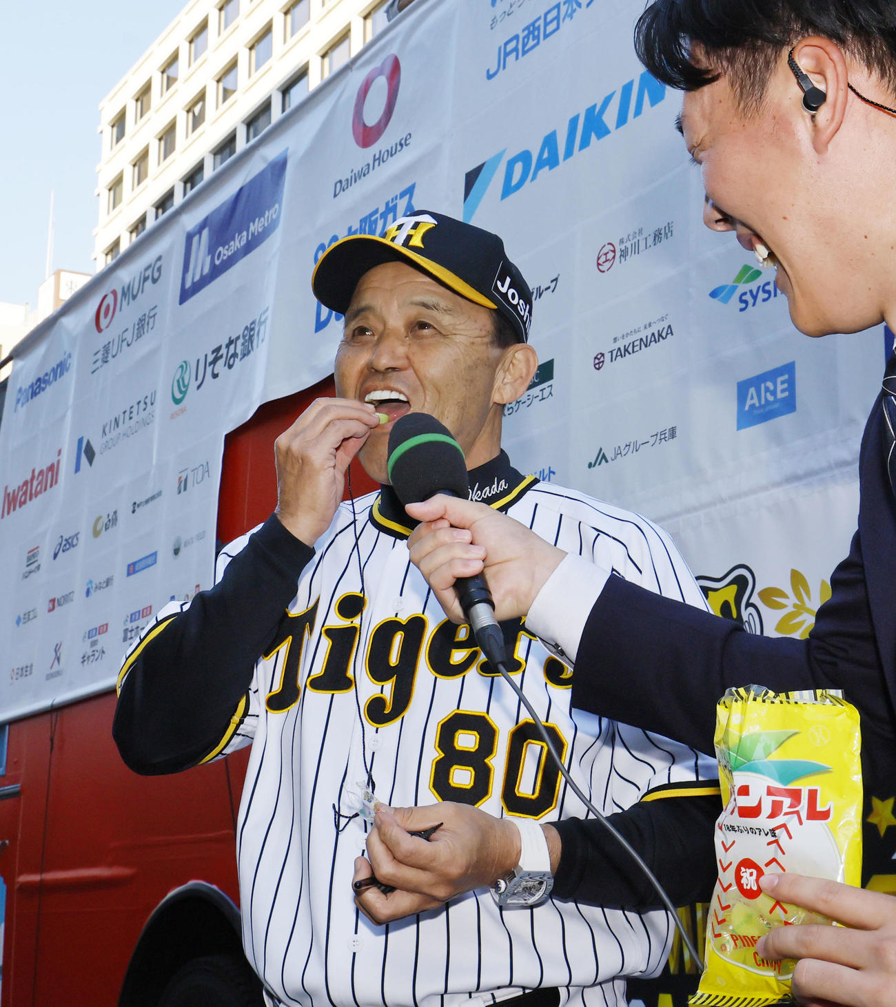 優勝パレードを終え、インタビューの終わりに「パインアレ」（パインアメ）を食べる阪神岡田監督（撮影・藤尾明華）
