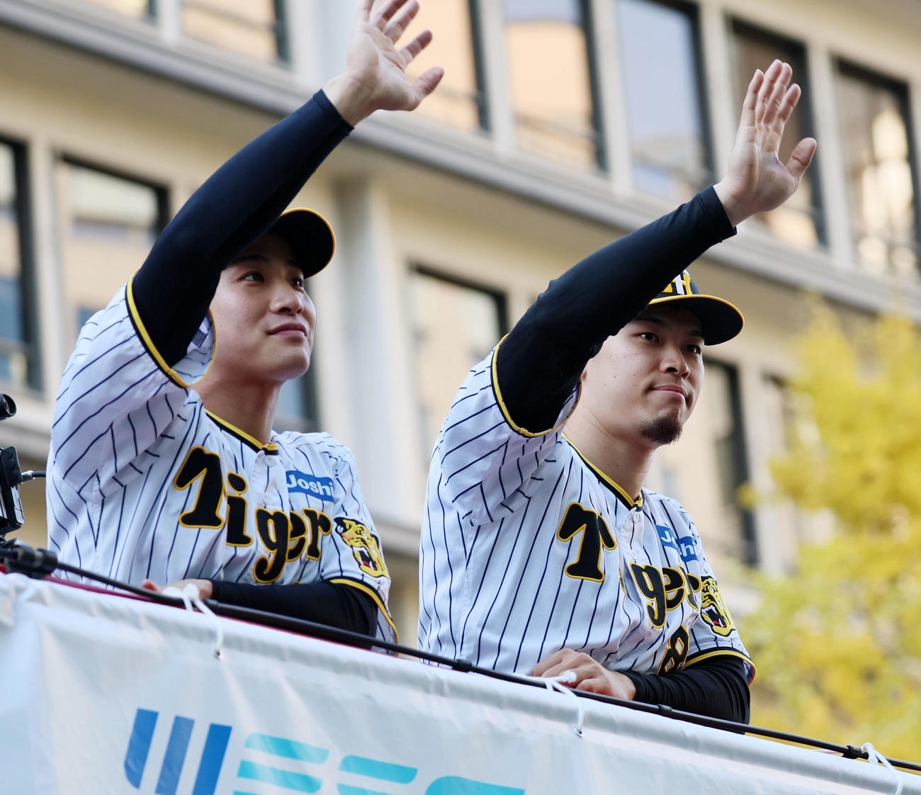 沿道に集まった多くのファンに手を振る木浪。右は佐藤輝（撮影・加藤哉）