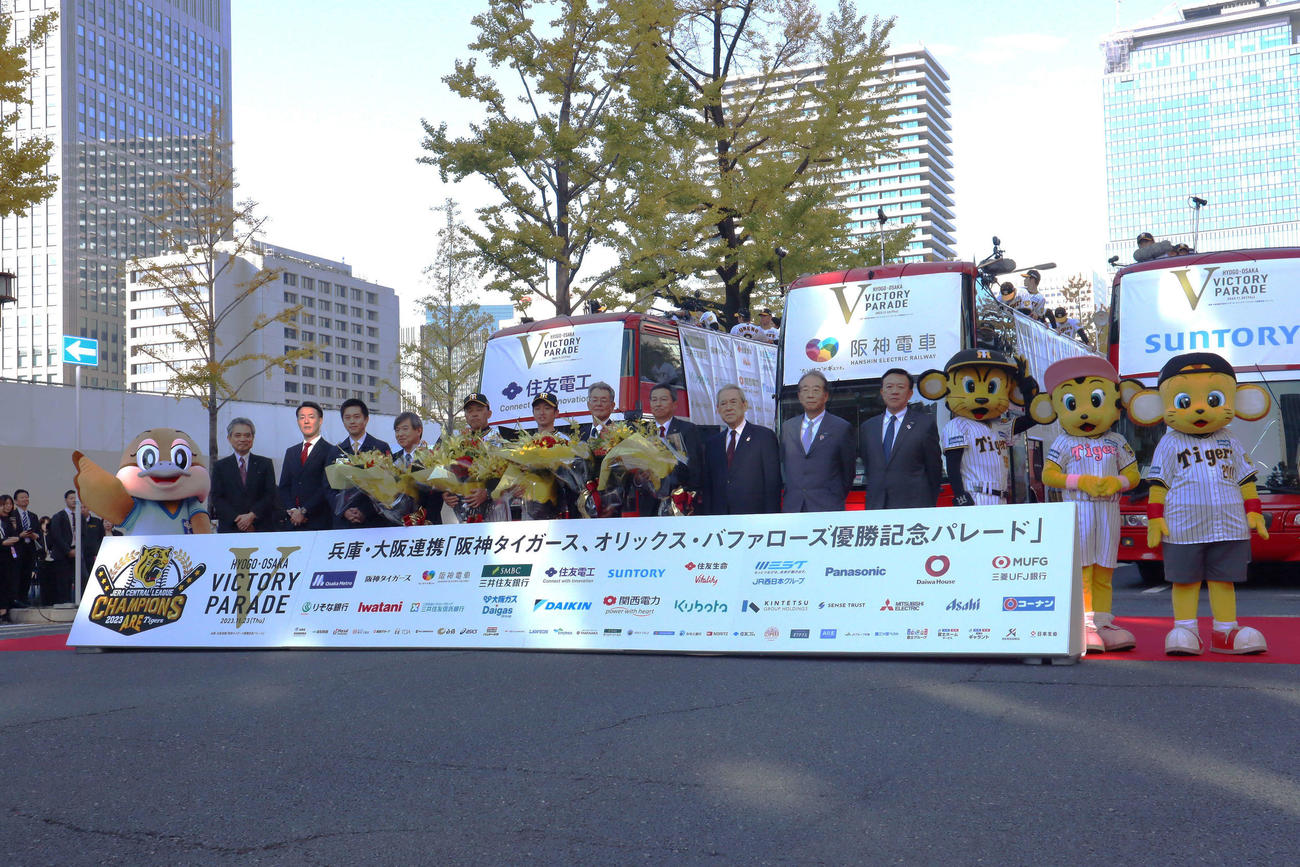 オープニングセレモニーで記念撮影する、左から崎本理事長、横山市長、吉村知事、杉山オーナー、岡田監督、近本選手会長、秦会長、百北社長、松本会長、鳥井会頭、角元代表幹事（撮影・村松万里子）