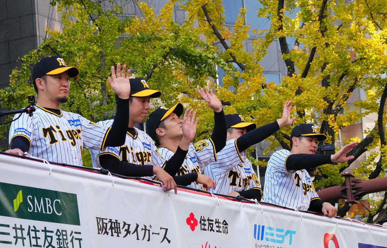 優勝パレードで、沿道のファンに手を振る（左から）阪神岩貞、青柳、坂本、木浪、佐藤輝（撮影・藤尾明華）