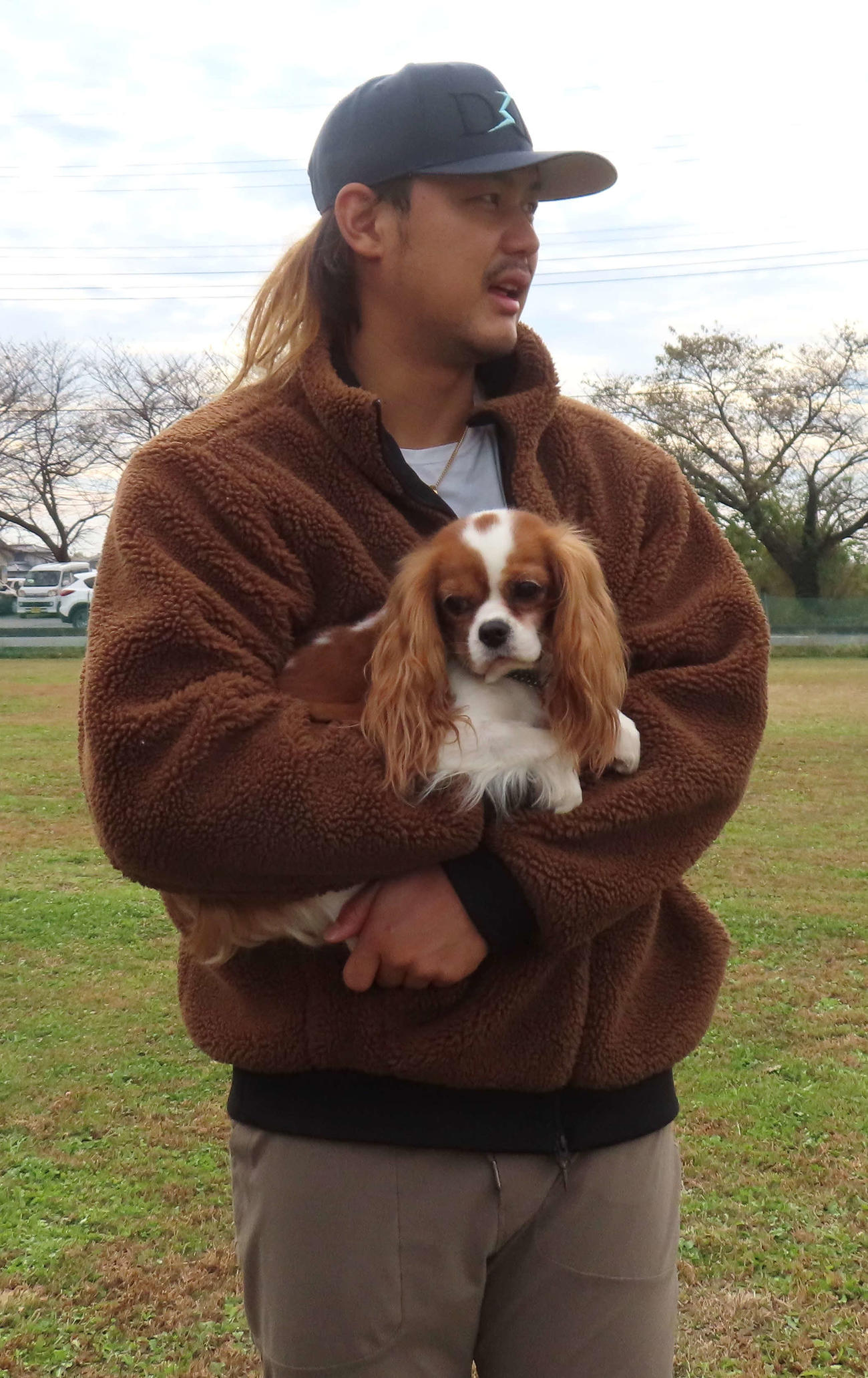 捜索救助犬コマを抱きかかえる西武・高橋