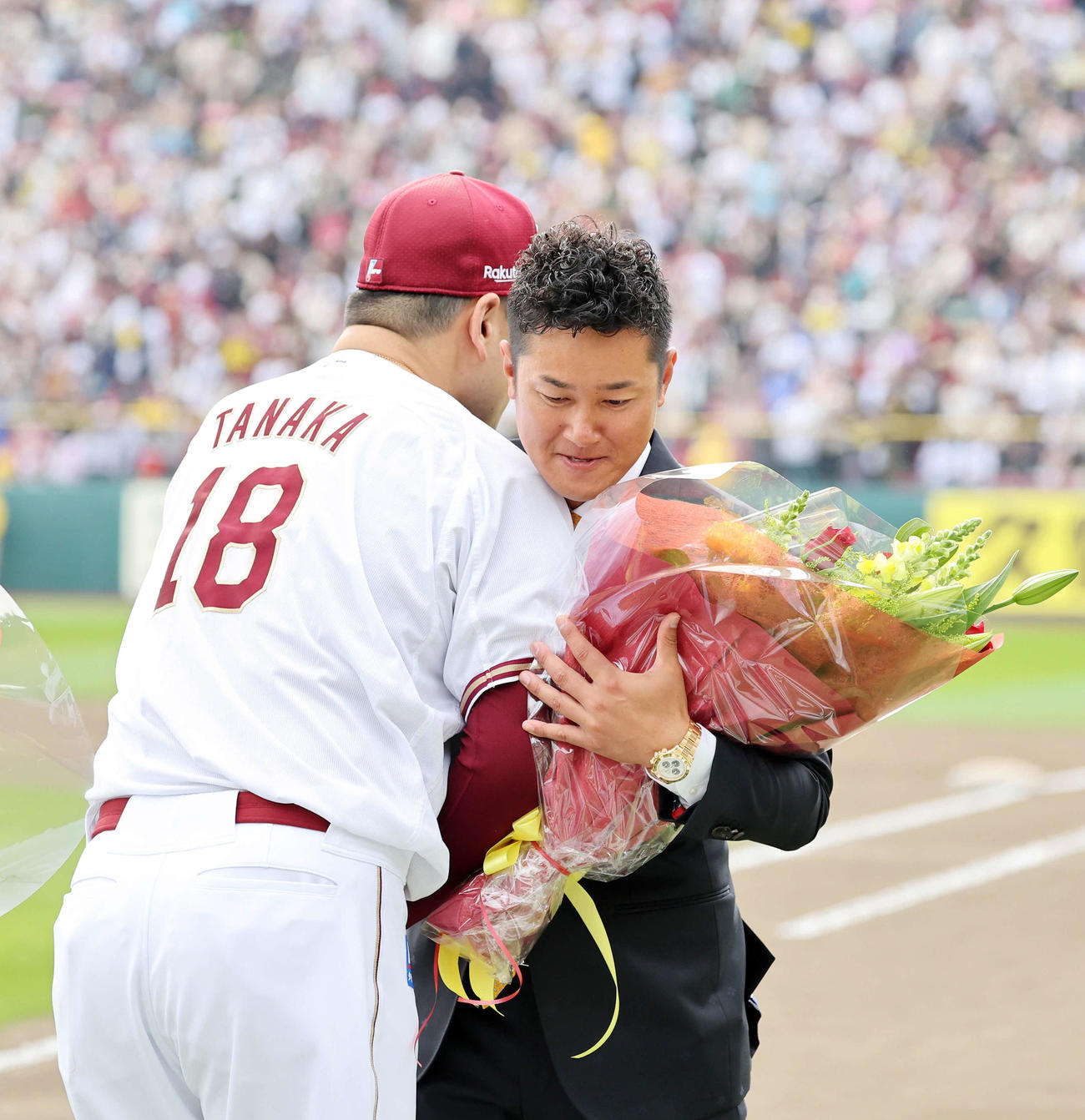 楽天田中将（左）から花束を受け取り抱き合う銀次（撮影・鈴木正人）