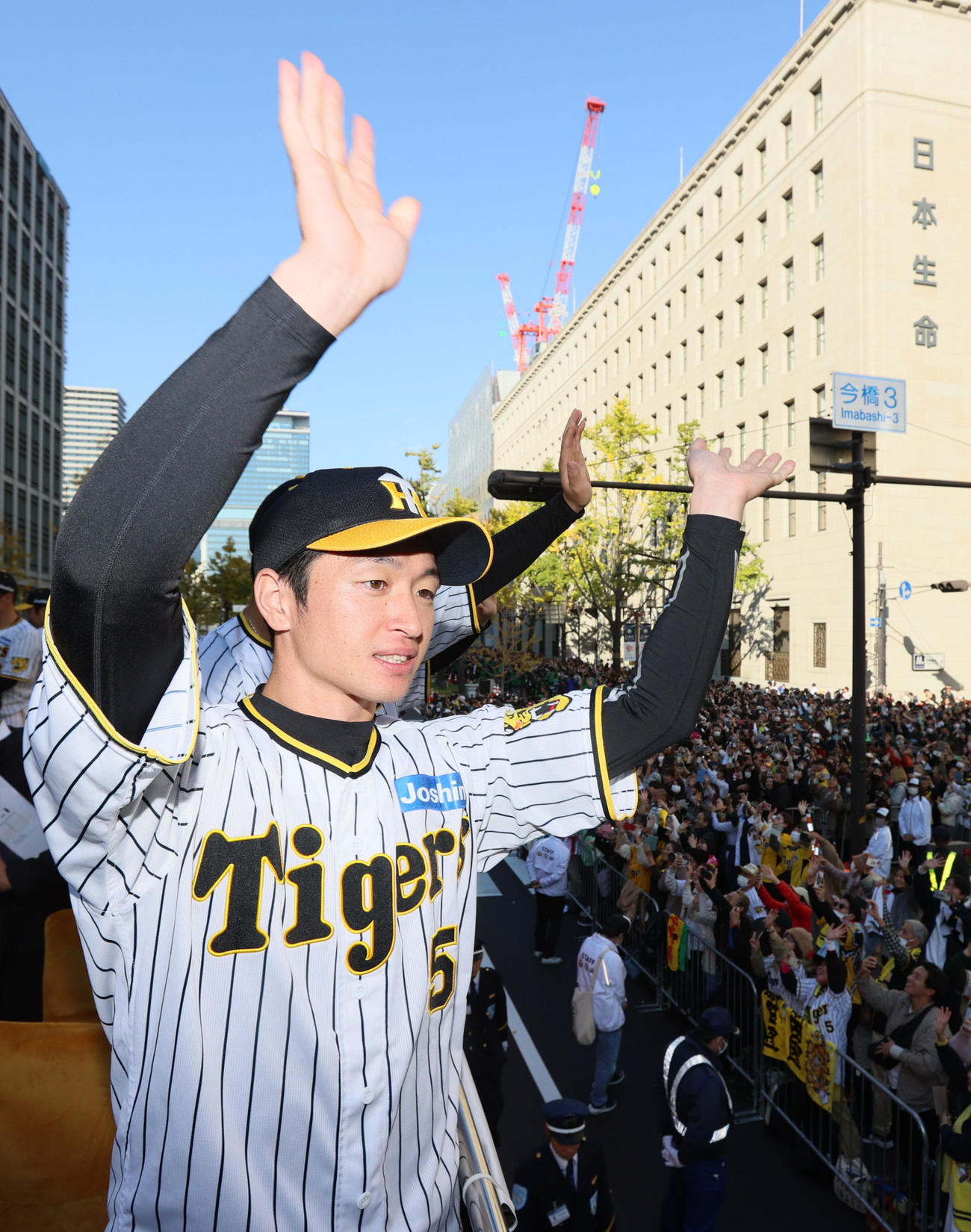 沿道に詰めかけたファンに手を振って応える阪神の近本（代表撮影）