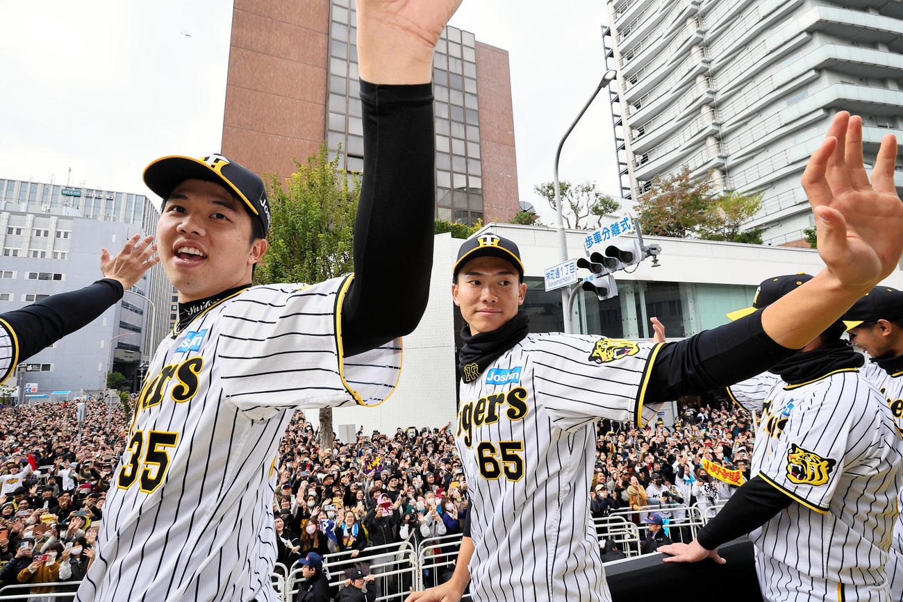 阪神の優勝パレードでファンに手を振る湯浅（右）と才木（代表撮影）