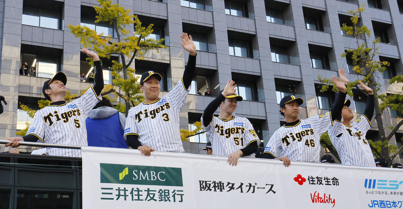 優勝パレードで、沿道のファンに手を振る（左から）阪神近本、大山、中野、島本、桐敷（撮影・藤尾明華）