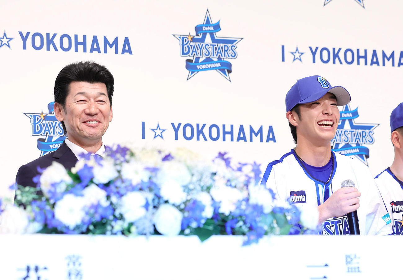 DeNA新入団選手発表会で笑顔を見せるドラフト1位の度会（右）。左は三浦監督（撮影・足立雅史）