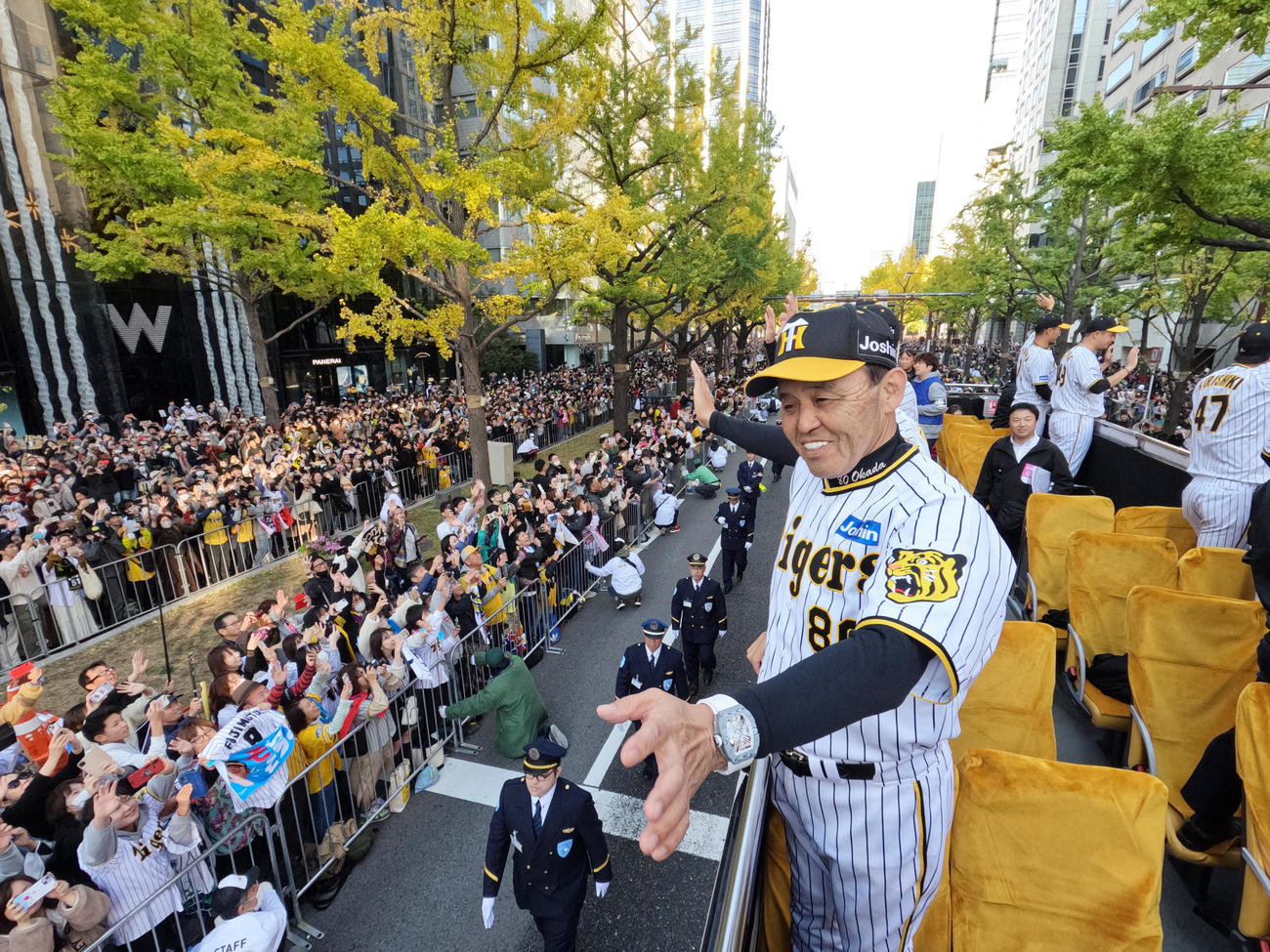 沿道に詰めかけたファンに手を振って応える阪神の岡田監督（手前）（代表撮影）