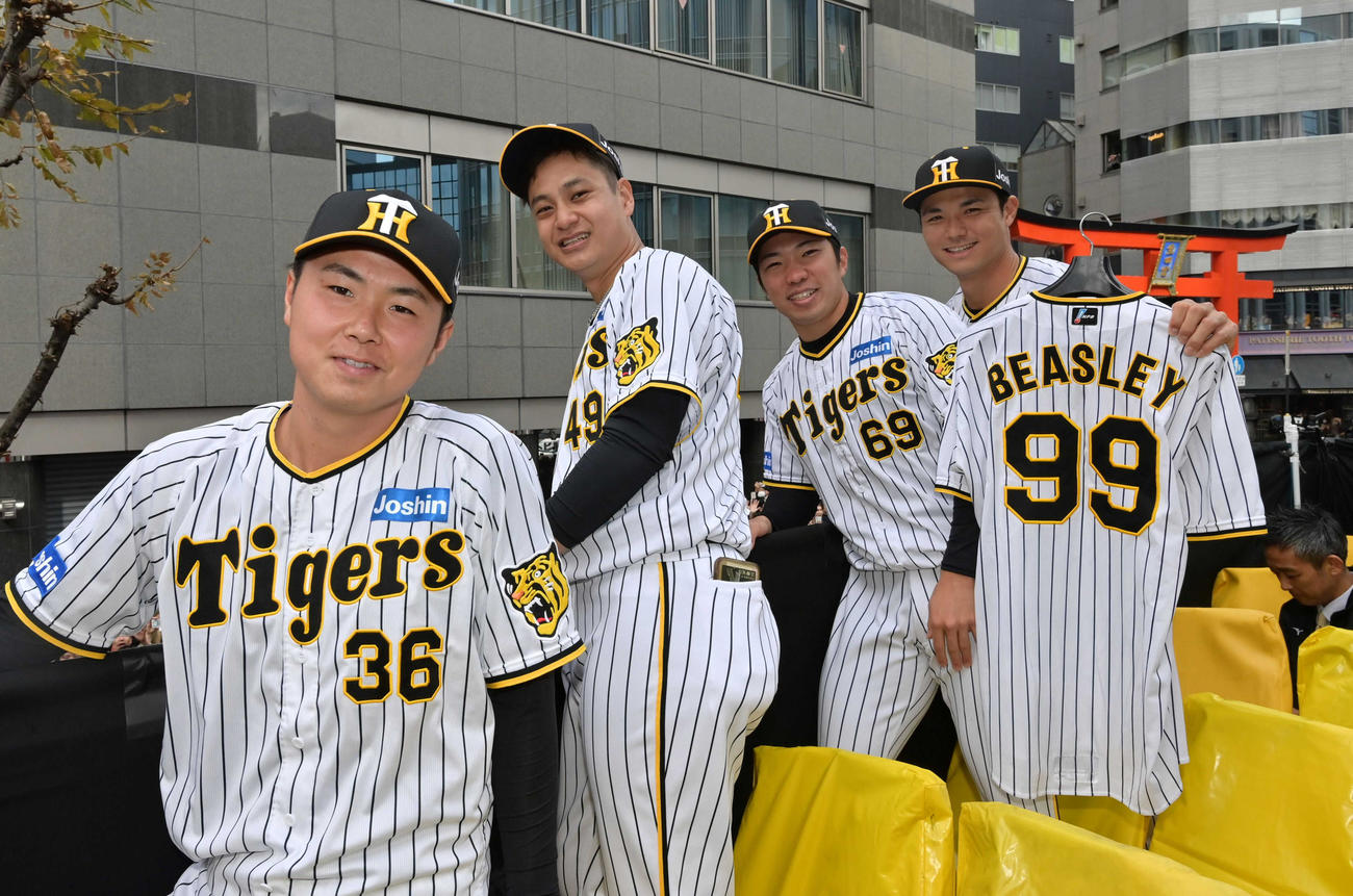 優勝パレードで、ビーズリーのユニホームを手に記念写真に納まる（左から）浜地、大竹、石井、栄枝（代表撮影）