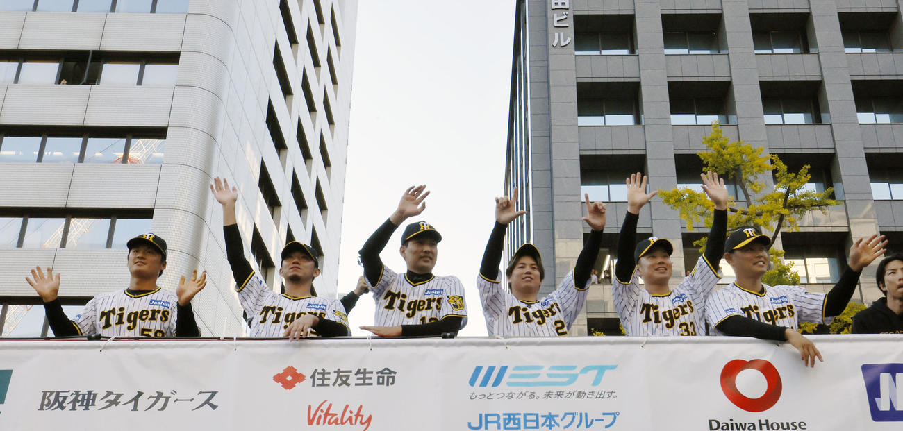 優勝パレードで、沿道のファンに手を振る（左から）阪神前川、伊藤将、岩崎、梅野、糸原、原口（撮影・藤尾明華）