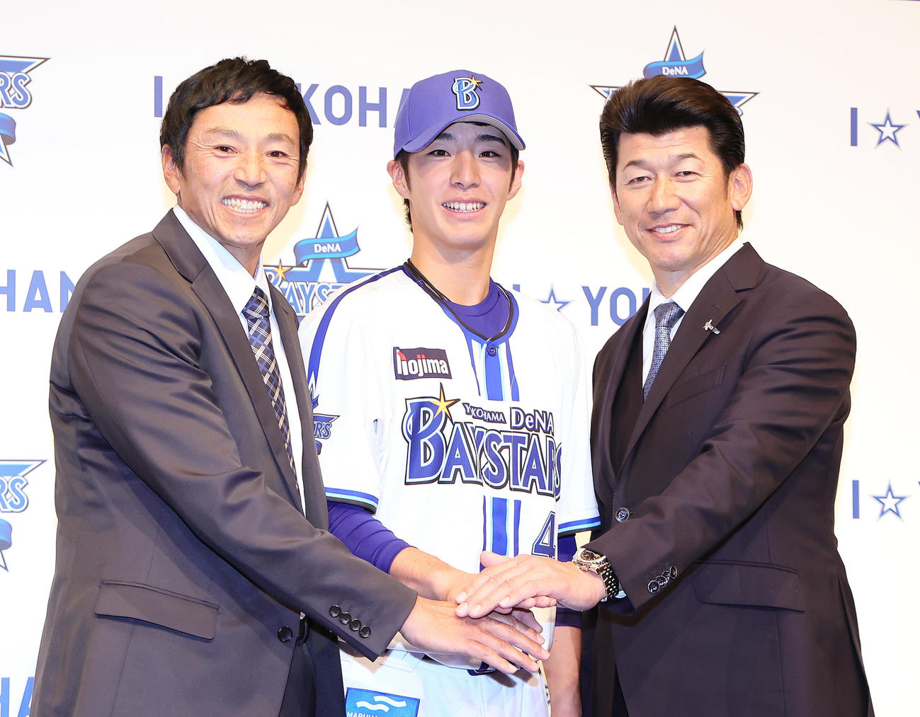 DeNA新入団選手発表会で記念撮影に笑顔を見せるドラフト1位度会（中央）。左は父博文さん、右は三浦監督（撮影・足立雅史）