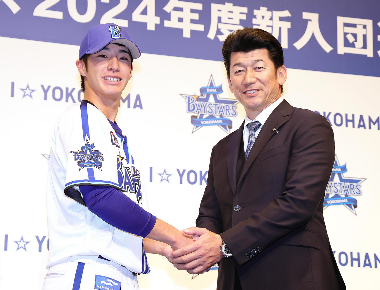 DeNA新入団選手発表会で握手を交わすドラフト1位度会（左）と三浦監督（撮影・足立雅史）