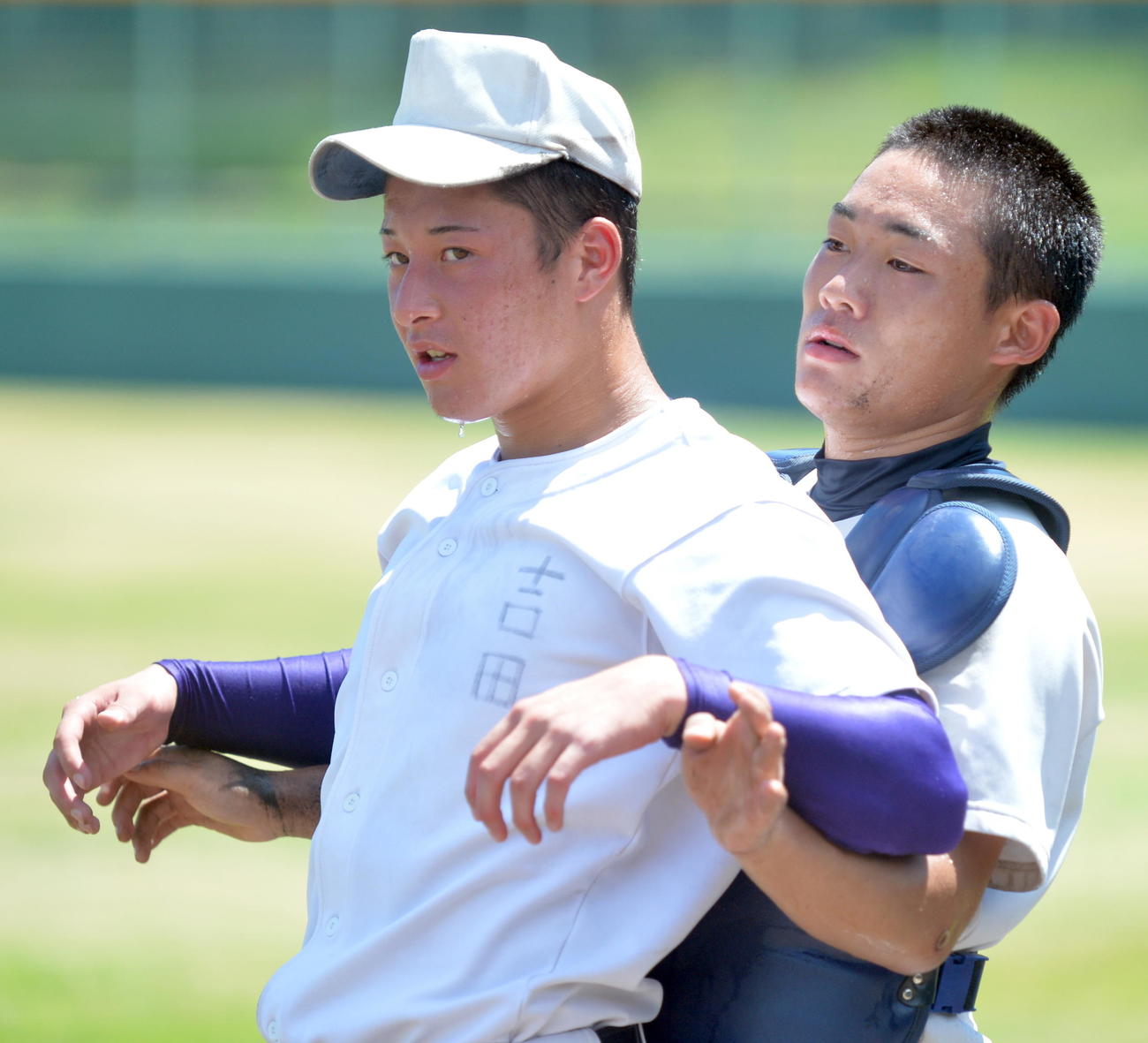 18年8月、夏の甲子園期間の練習中に大粒の汗を流しながら仲間とストレッチを行う金足農エース吉田輝星投手（左）（撮影・鎌田直秀）
