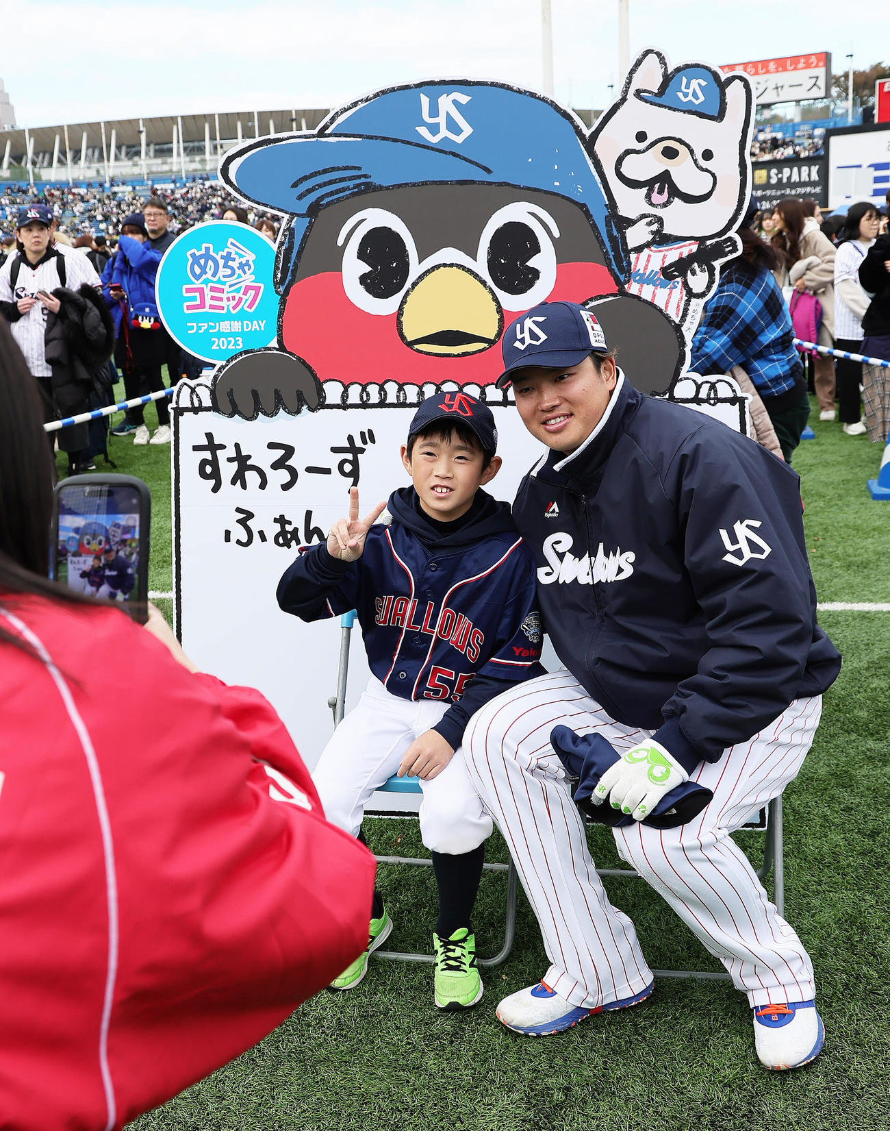 ファンのこどもとの記念撮影に笑顔を見せるヤクルト村上（撮影・足立雅史）
