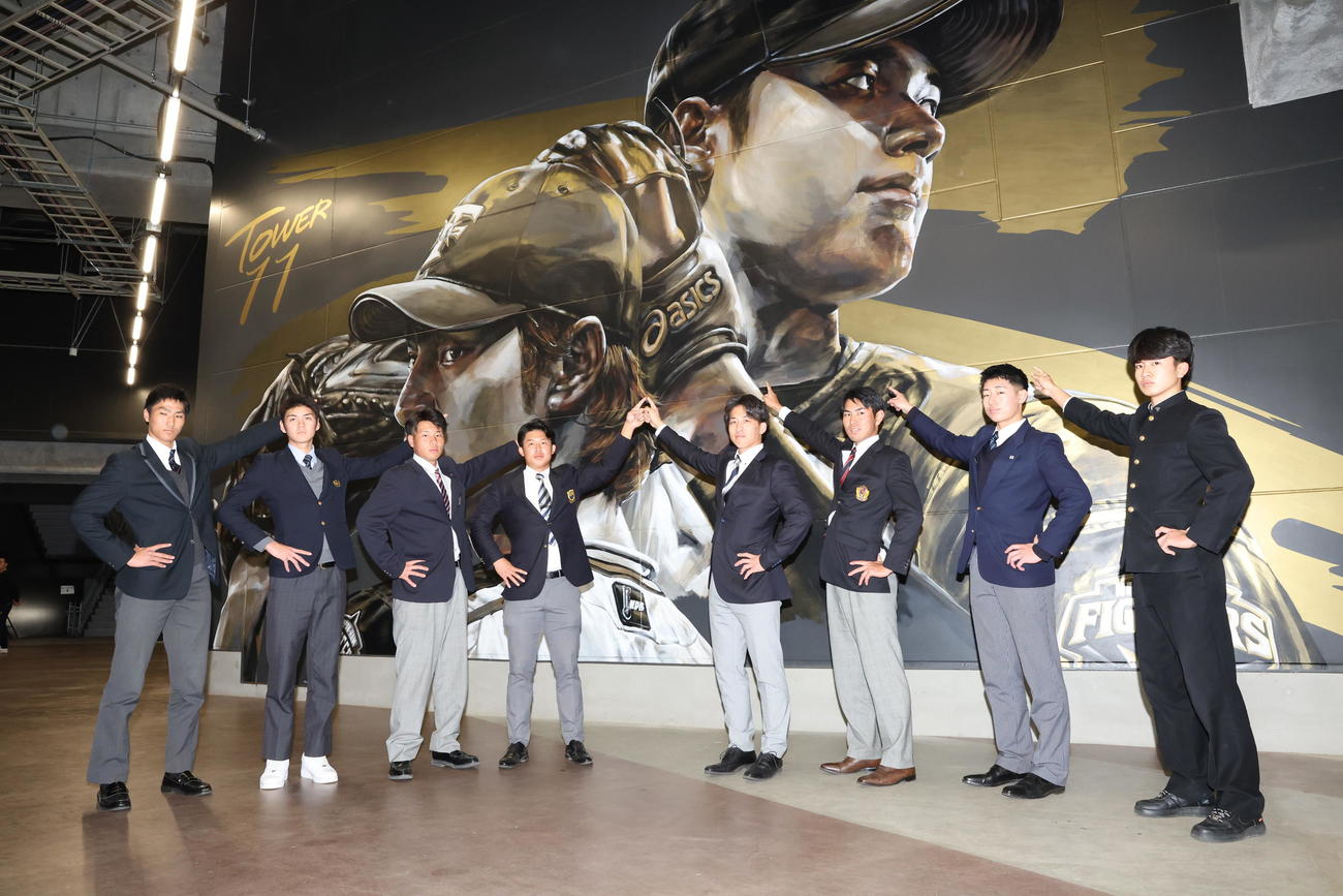 エスコンフィールド北海道内のダルビッシュ、大谷の壁画の前でポーズをとる日本ハム新入団選手の左から育成3位加藤大、育成1位浜田、4位明瀬、2位進藤、1位細野、3位宮崎、5位星野、育成2位平田（撮影・黒川智章）