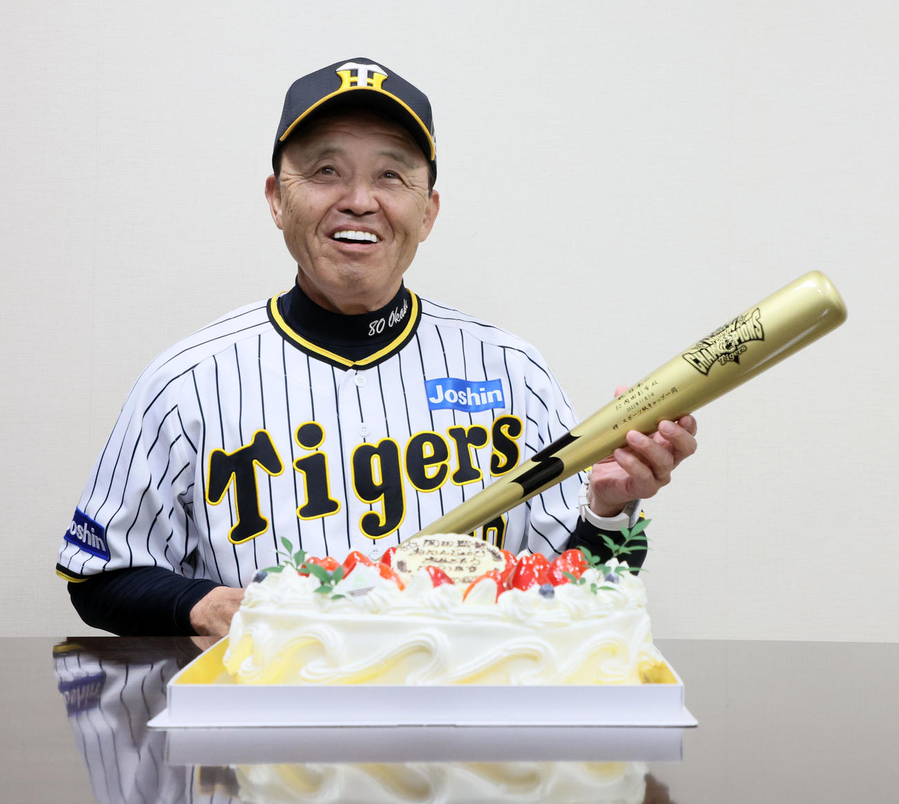 バースデーケーキを前に記者から送られた金のバットを手に笑顔を見せる岡田監督（撮影・加藤哉）