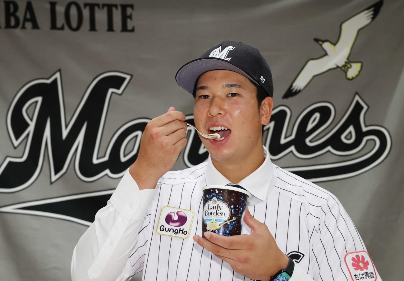 契約を終え、大好きなロッテのアイスクリーム「レディーボーデン」をほおばるロッテドラフト1位の明大・上田（撮影・宮地輝）