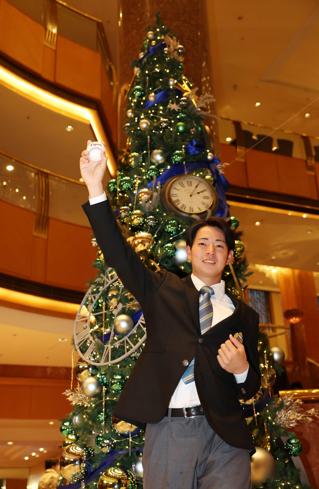 仮契約を終え、クリスマスツリーを背に投球フォームを披露する阪神ドラフト1位の青学大・下村（撮影・宮地輝）