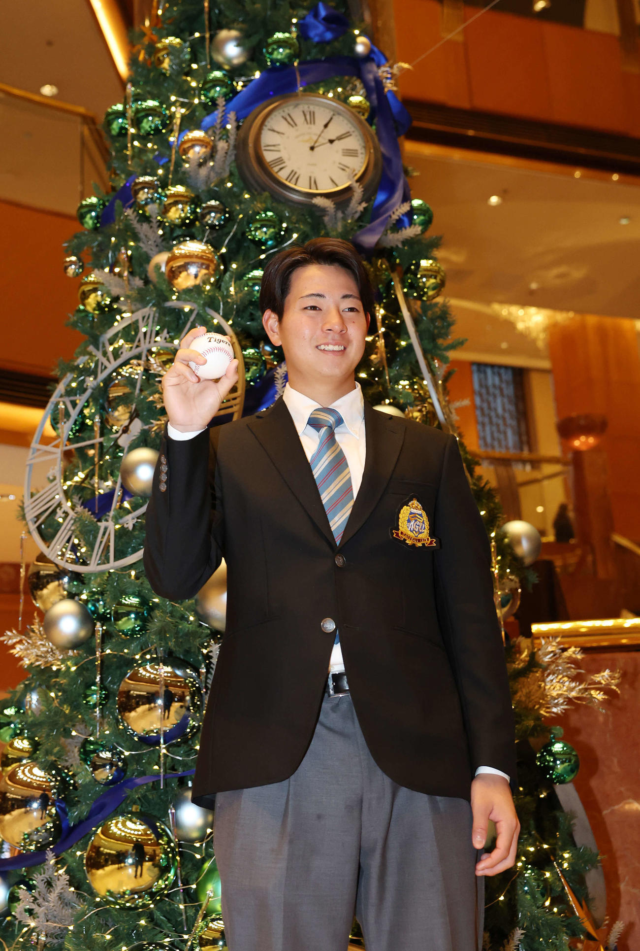 仮契約を終え、クリスマスツリーを背に笑顔を見せる阪神ドラフト1位の青学大・下村（撮影・宮地輝）