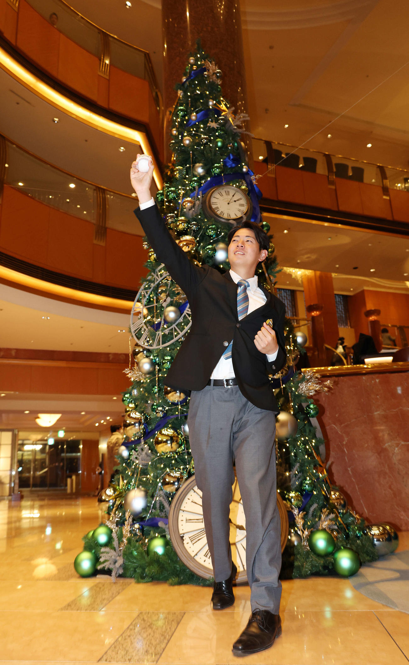 仮契約を終え、クリスマスツリーを背に投球フォームを披露する阪神ドラフト1位の青学大・下村（撮影・宮地輝）