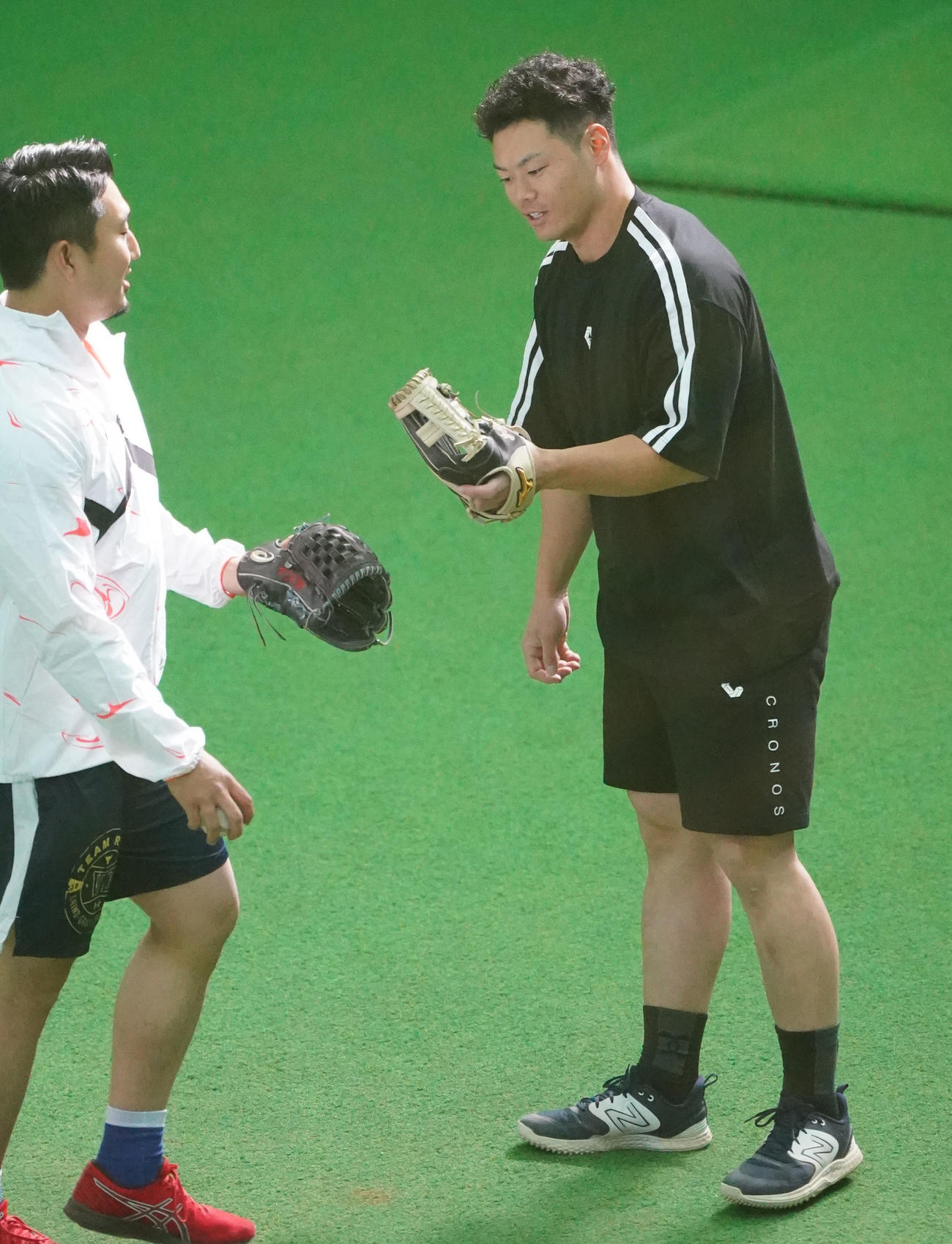 キャッチボールを終え藤嶋とタッチを交わす細川（右）（撮影・森本幸一）