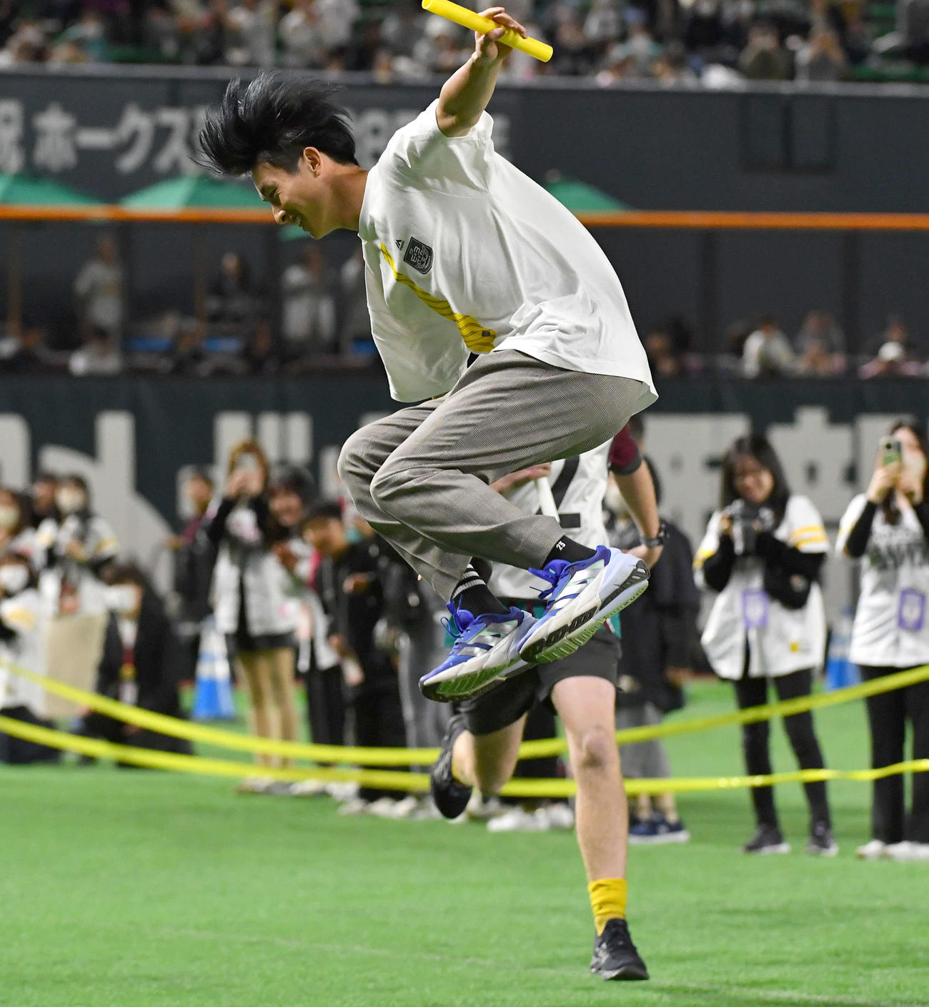 リレーのアンカーでジャンプしながらゴールする周東（撮影・岩下翔太）