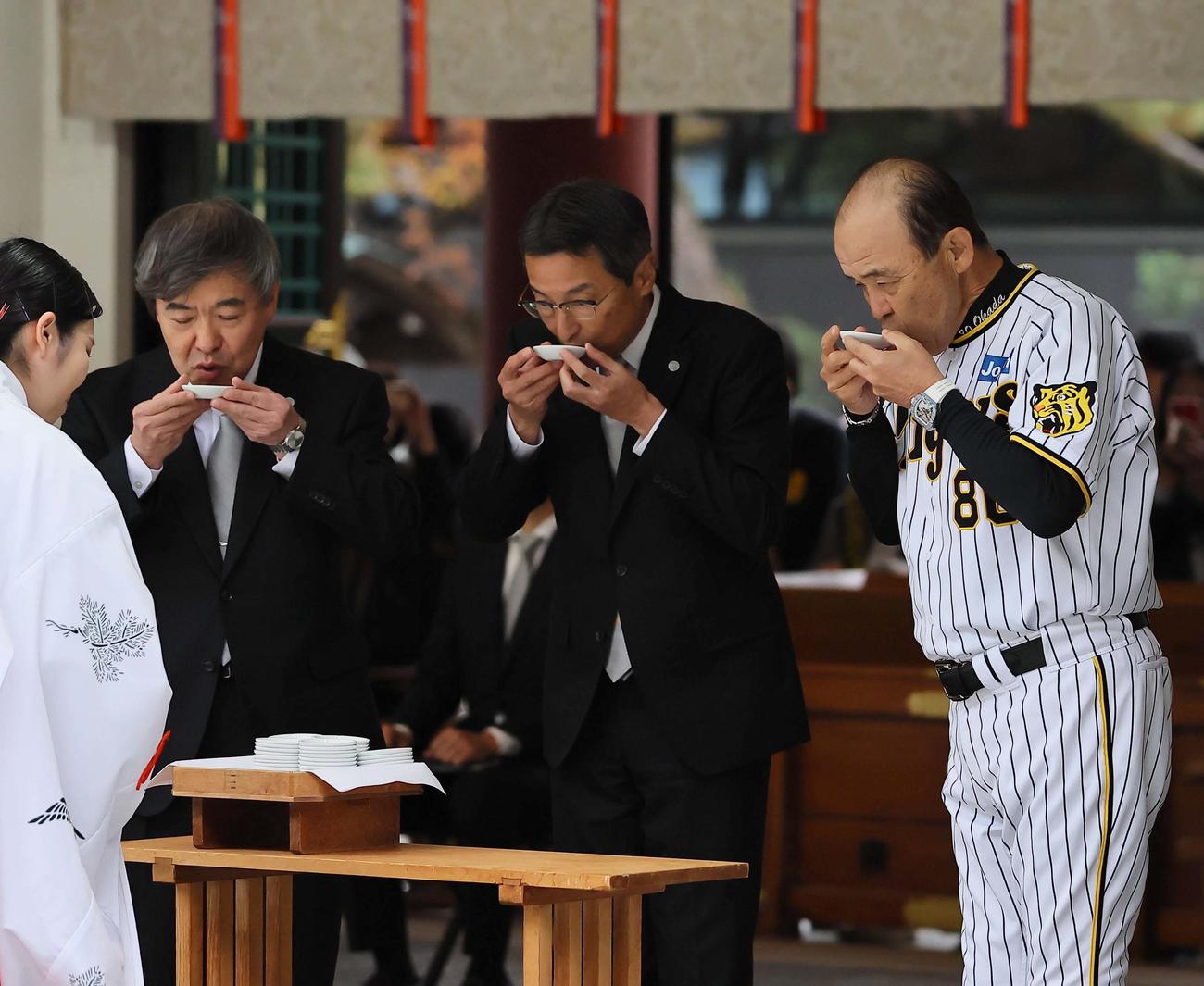 西宮神社を参拝する右から岡田監督、百北社長、杉山オーナーは御神酒を受ける（撮影・上田博志）