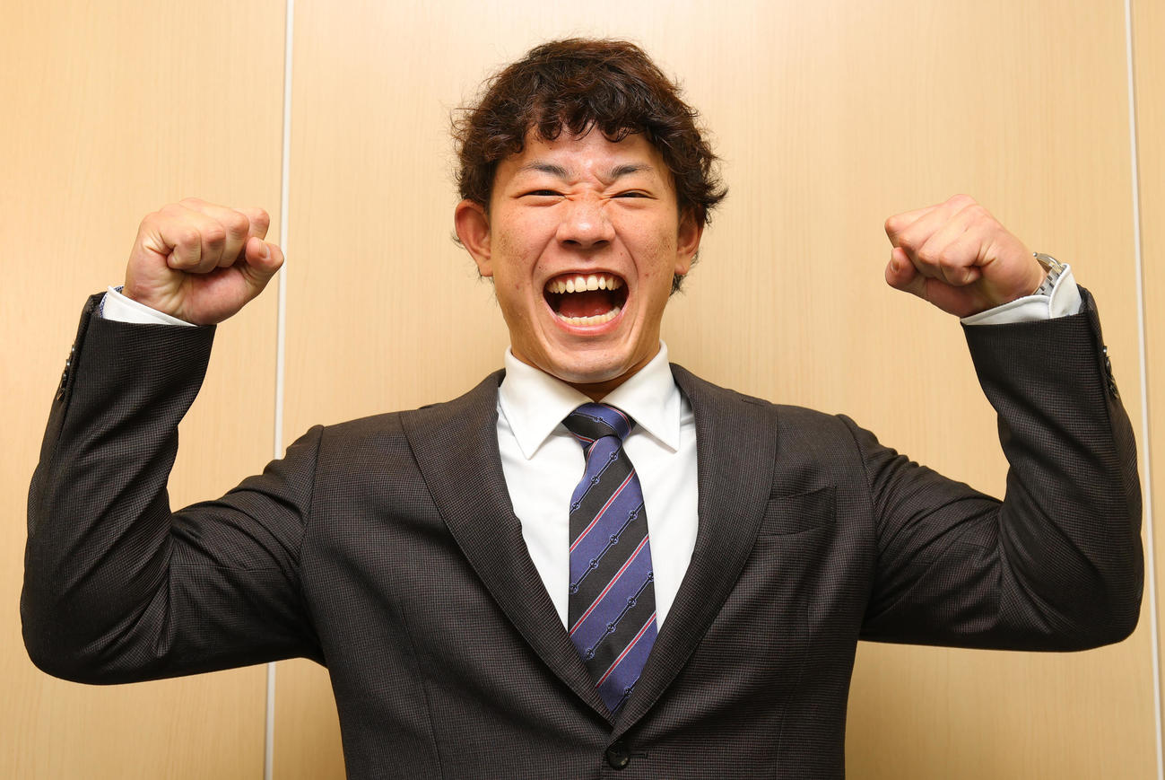 入団会見で気合のガッツポーズを見せるヤクルト増田（撮影・野上伸悟）